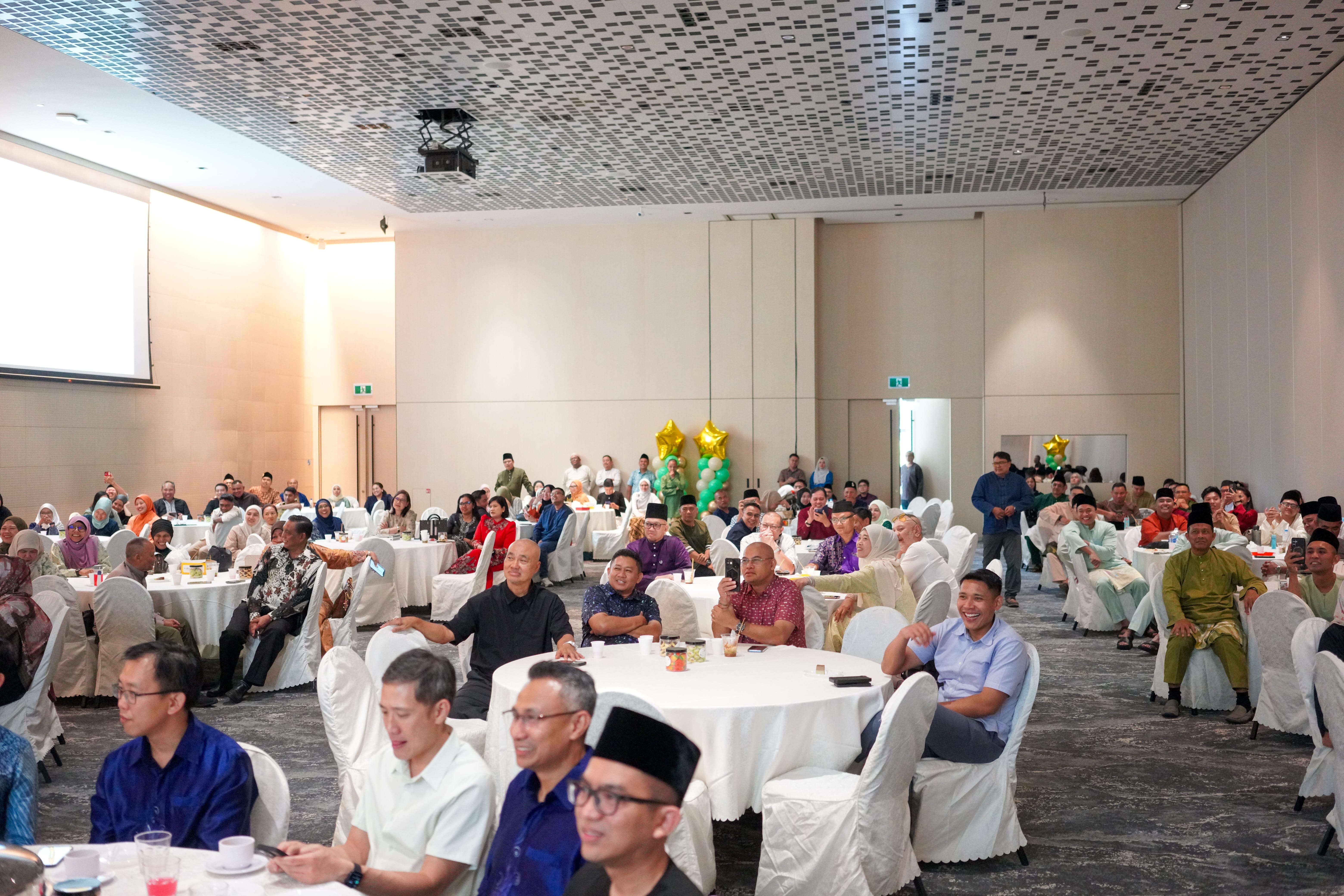 Attendees seated across a banquet hall watching a stage performance.